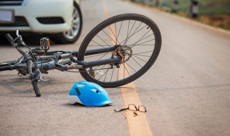 Bicycle and helmet on road after car right hook accident representing bike accident injury claims in New York