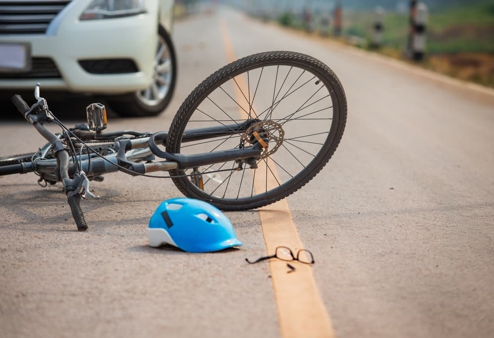 Bicycle and helmet on road after car right hook accident representing bike accident injury claims in New York