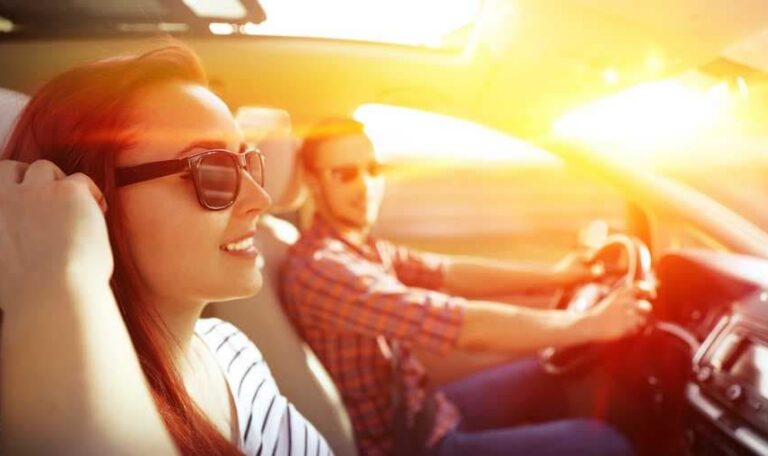 Couple driving car in summer sunshine representing safe driving tips for New York drivers