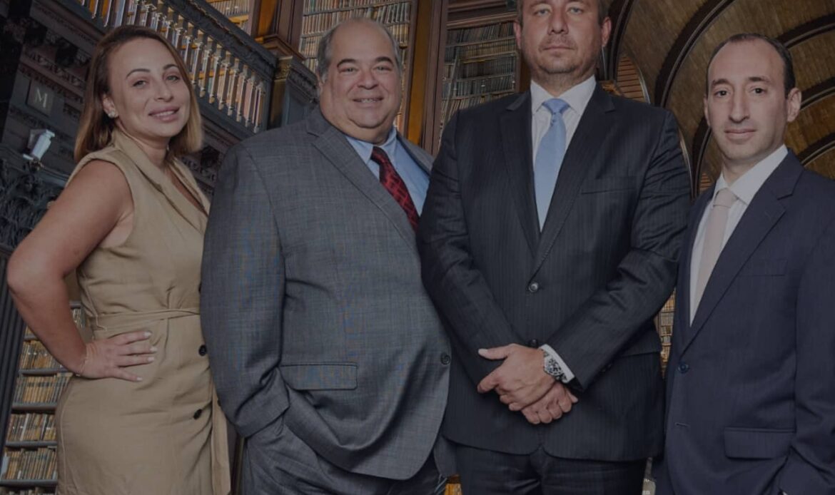 The Rybak Firm PLLC four attorneys standing in historic law library Brooklyn New York