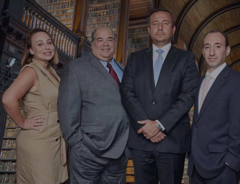 The Rybak Firm PLLC four attorneys standing in historic law library Brooklyn New York