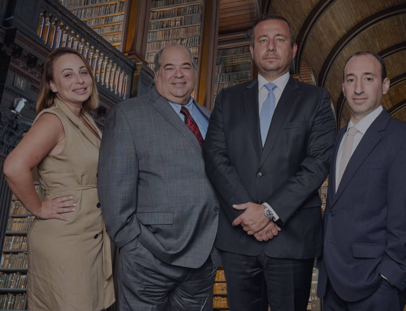 The Rybak Firm PLLC four attorneys standing in historic law library Brooklyn New York