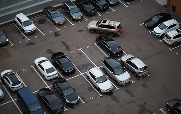 Aerial view of a parking lot with parked cars in marked spaces