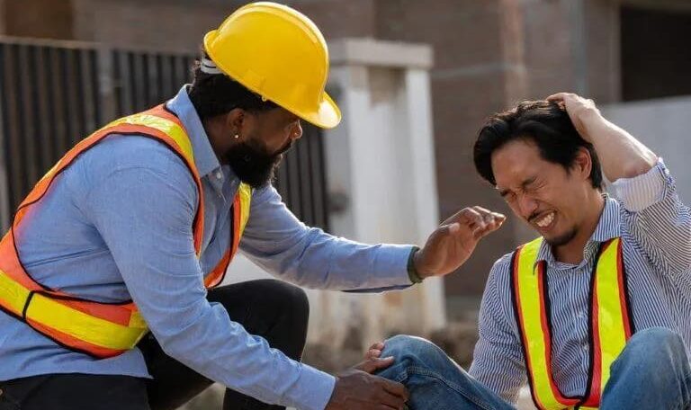 Construction worker helping an injured coworker at a New York job site