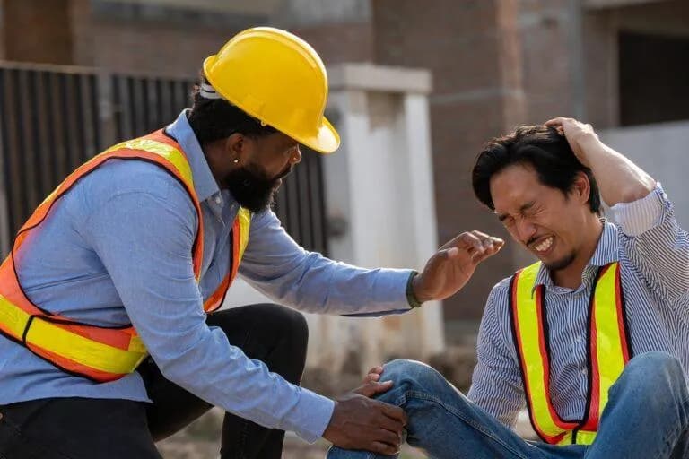 Construction worker helping an injured coworker at a New York job site