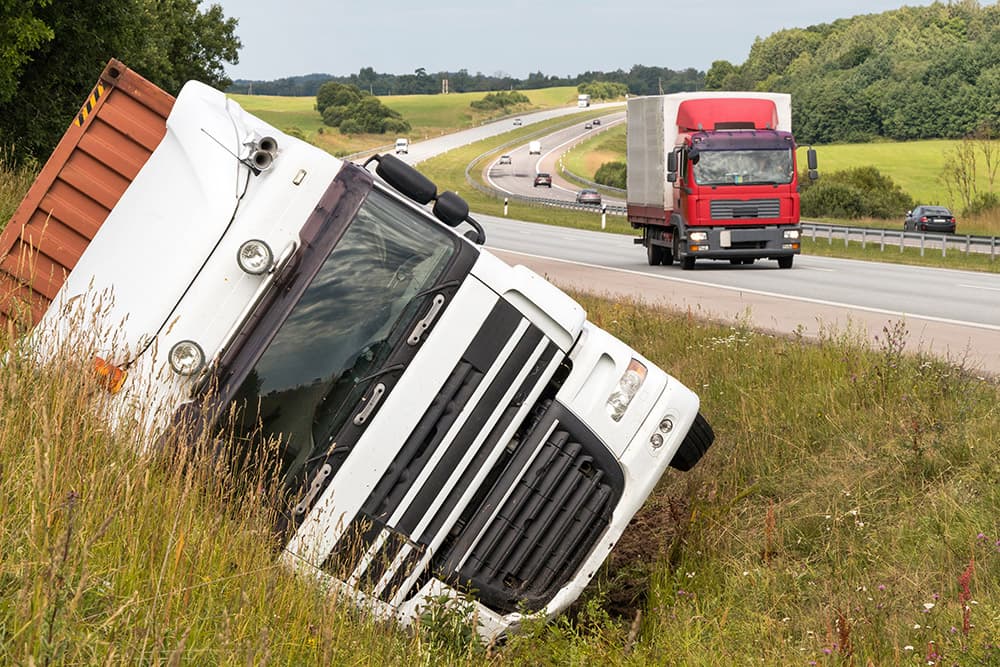 Overturned tractor-trailer on the side of a highway after a rollover truck accident