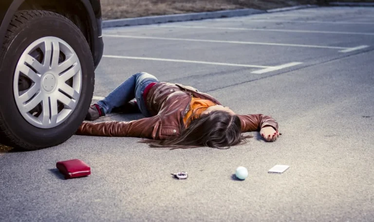 Pedestrian lying on the pavement after being struck by a vehicle, with belongings scattered nearby — pedestrian accident lawyer NYC