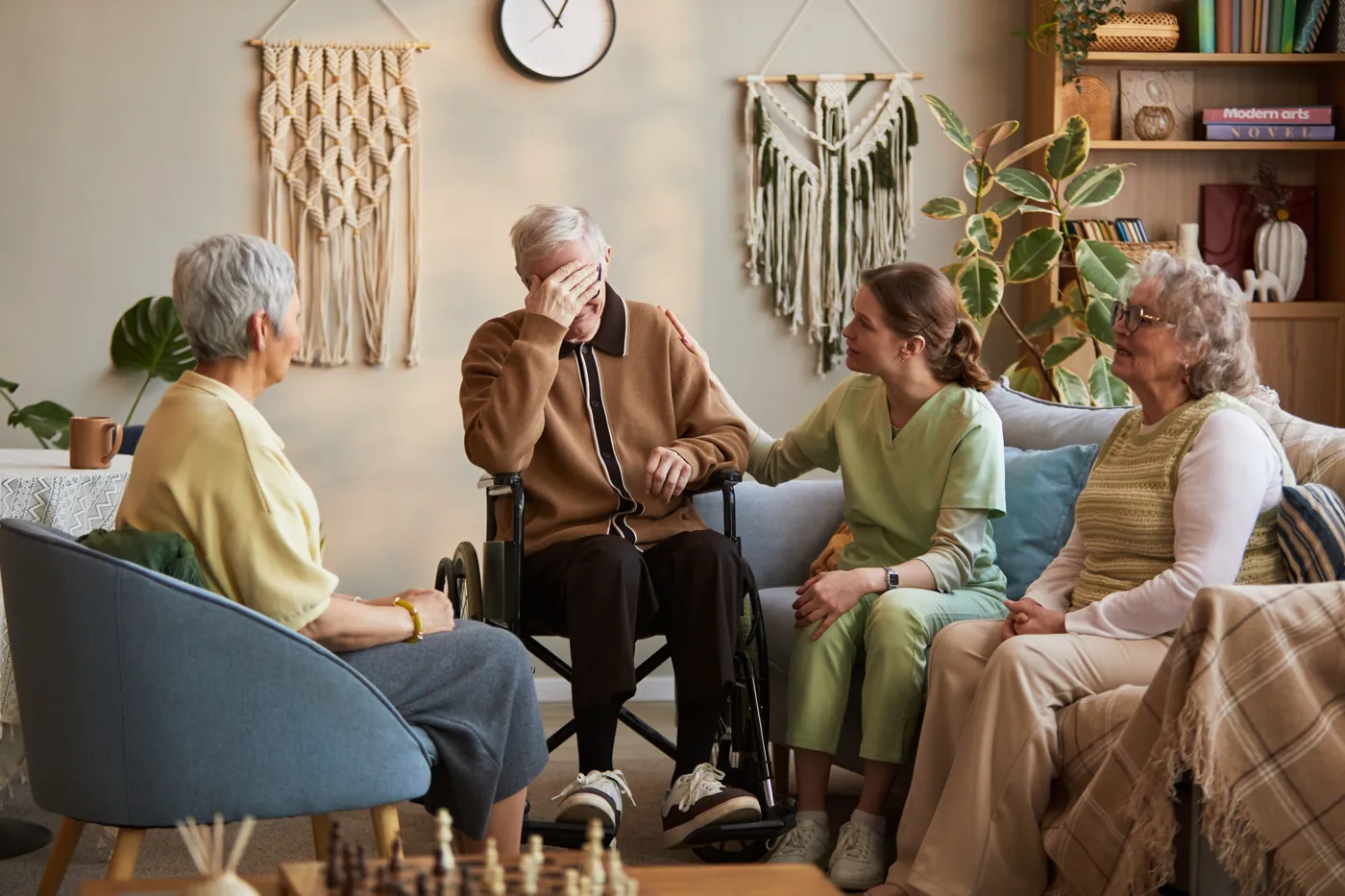 Caregiver comforting an upset elderly man in a wheelchair at a nursing home in Brooklyn