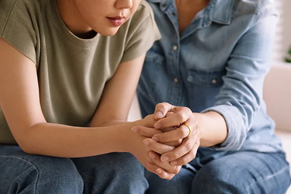 Woman comforting a family member after a cancer misdiagnosis in New York